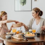 A warm family breakfast with mother and daughter sharing a meal in a cozy dining area.